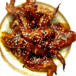 Platter of golden, crispy pellet-smoked wings drizzled with a sticky garlic honey maple buffalo sauce.