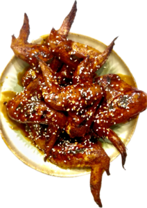 Platter of golden, crispy pellet-smoked wings drizzled with a sticky garlic honey maple buffalo sauce.