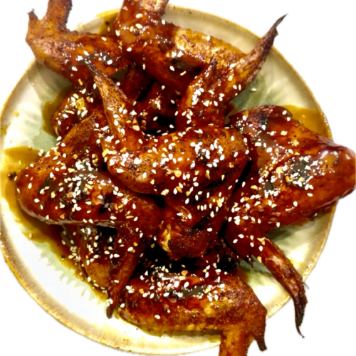 Platter of golden, crispy pellet-smoked wings drizzled with a sticky garlic honey maple buffalo sauce.